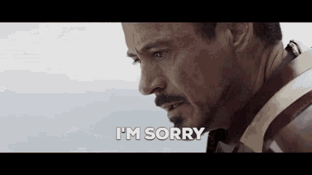 a close up of a man 's face with the words `` i 'm sorry '' written on it .