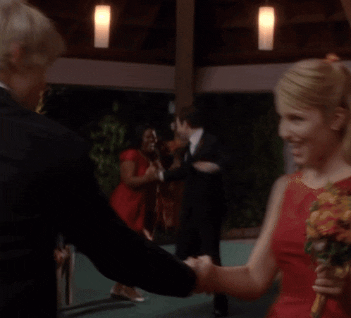 a blurry picture of a woman in a red dress standing next to a man in a suit