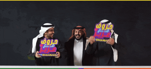 three men are holding up signs with arabic writing on them and confetti is falling around them