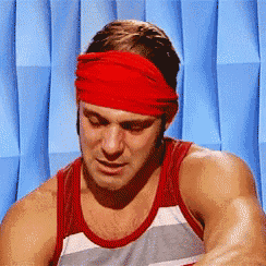 a man is wearing a red headband and a striped tank top