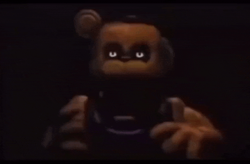 a close up of a teddy bear with glowing eyes in the dark