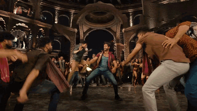 a man stands in front of a crowd of people dancing