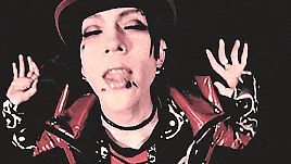 a close up of a person wearing a hat and choker .