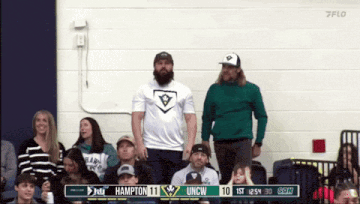 a group of people watching a game with hampton 11 uncw 10