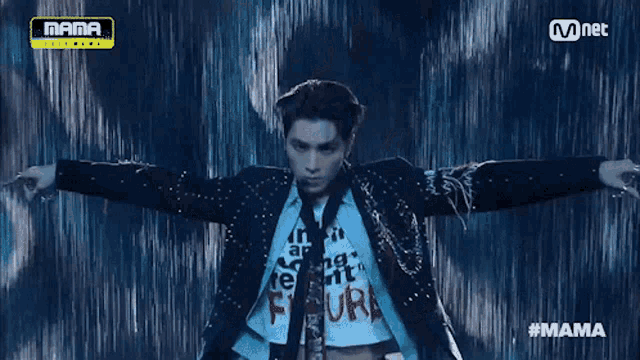 a man in a suit and tie is dancing on a stage in front of a mnet logo