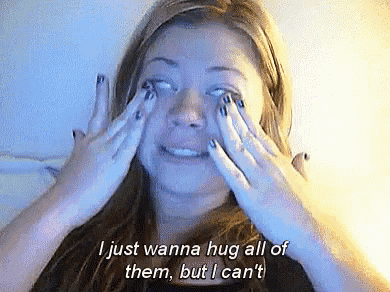 a woman covering her eyes with her hands with the words " i just wanna hug all of them but i can 't " below her