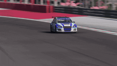 a blue and white racing car with adrian flux on the side