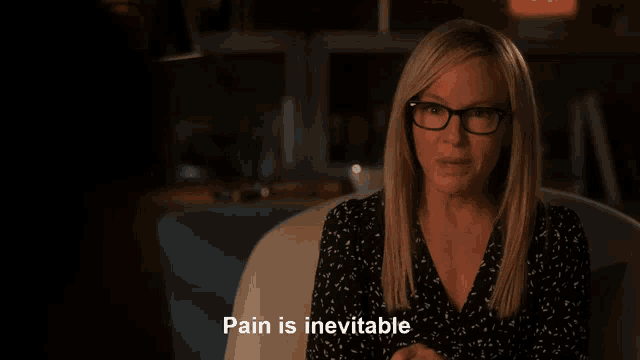 a woman sitting in a chair with the words pain is inevitable above her