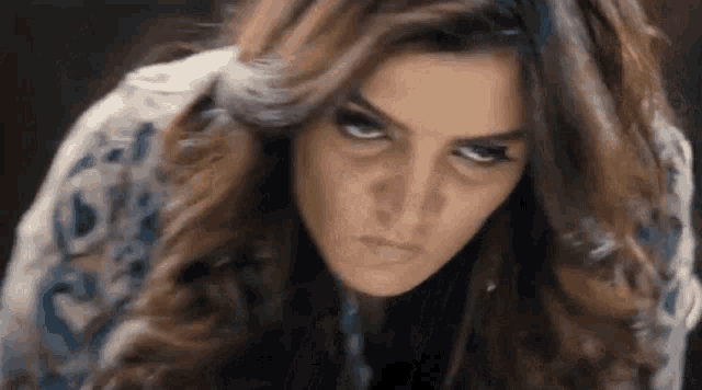 a close up of a woman making a funny face with her eyes closed .