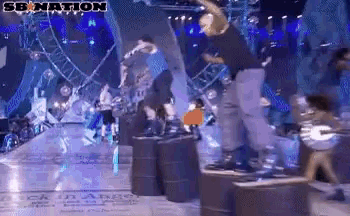 a group of people are dancing on a stage with a sign that says senation