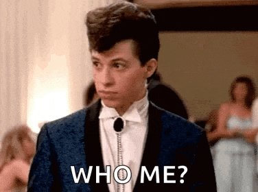a young man in a suit and tie is asking who me ?