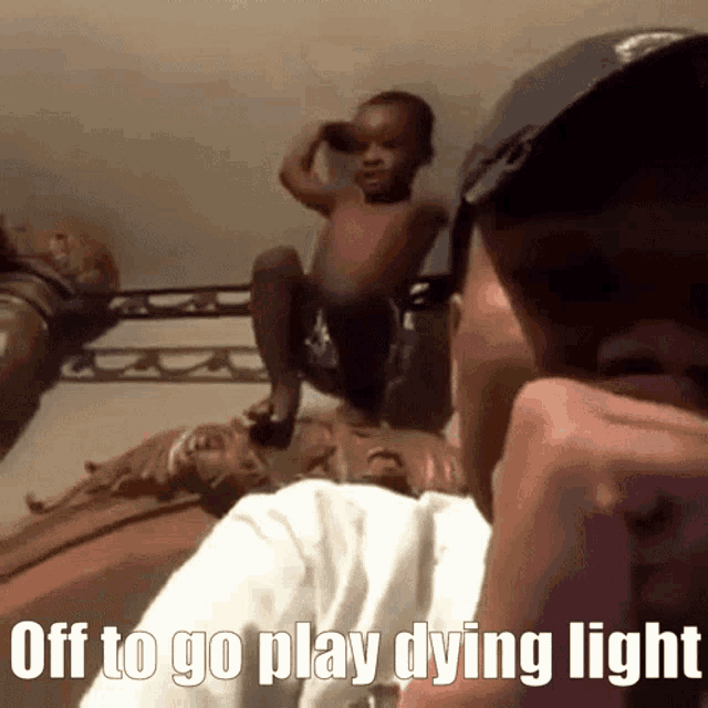 a man talking on a cell phone with a baby on his lap and the words off to go play dying light above him