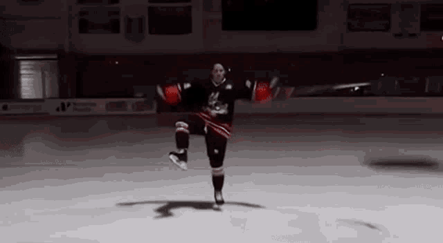 a hockey player is doing a trick on the ice in a stadium .