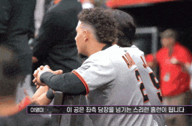 two baseball players with asian writing on the bottom of the screen