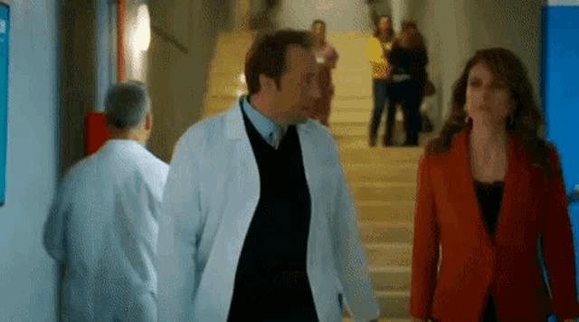 a man in a lab coat is walking with a woman