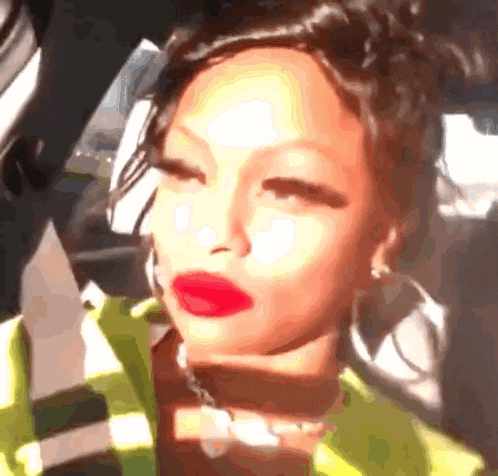 a close up of a woman 's face with red lipstick and hoop earrings