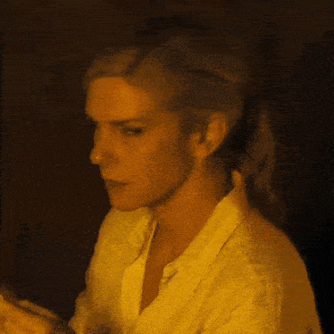 a close up of a woman 's face in a yellow shirt .