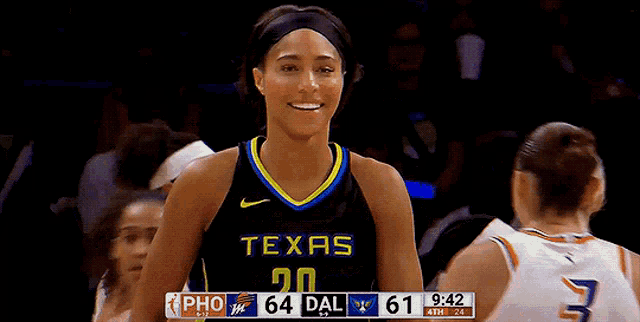 a female basketball player wearing a texas jersey smiles