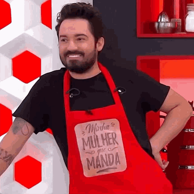a man wearing a red apron that says minha mulher manda on it