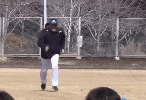 a man in a black jacket and white pants is running on a field .