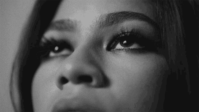 a black and white photo of a woman 's face looking up