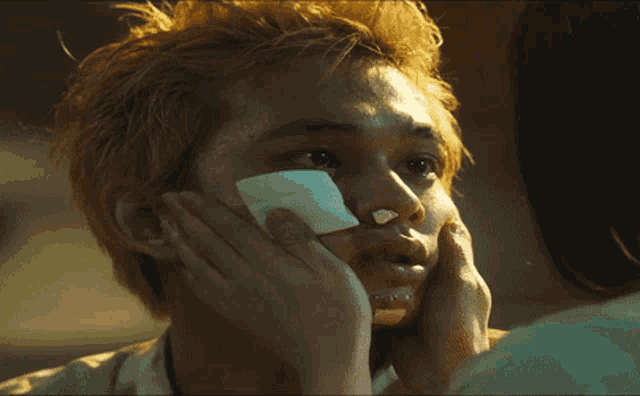 a man with a bandage on his face looks at another man