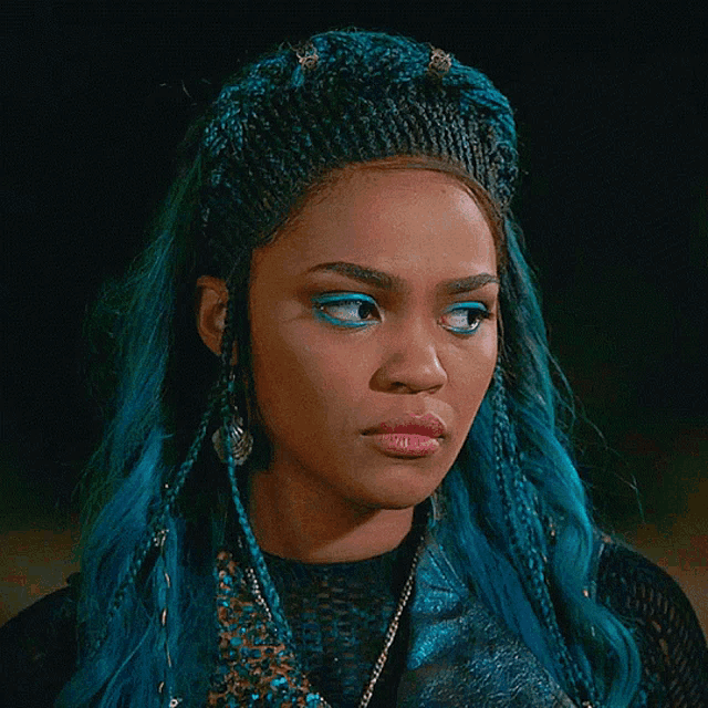 a woman with blue hair is wearing a black top