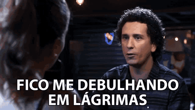 a man with curly hair is talking to a woman with the words fico me debulhando em lagrimas above him