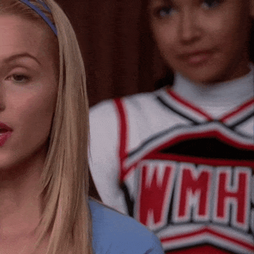 a cheerleader wearing a wmhs uniform stands next to a blonde girl