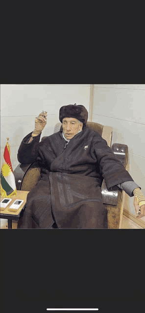 a man in a fur coat is sitting in a chair with a cigarette in his hand