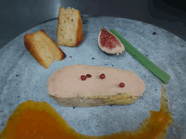 a plate of food with a slice of fig and a piece of cake on it
