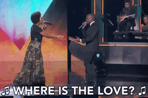 a man and a woman singing on stage with the words where is the love
