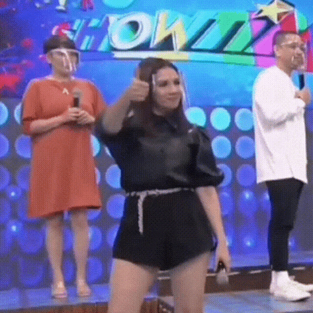 a woman is giving a thumbs up in front of a sign that says showtime