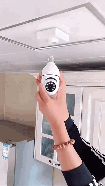 a person is holding a light bulb with a camera attached to it