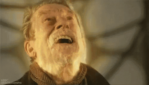 an older man with a beard is laughing with his mouth open and his eyes closed .
