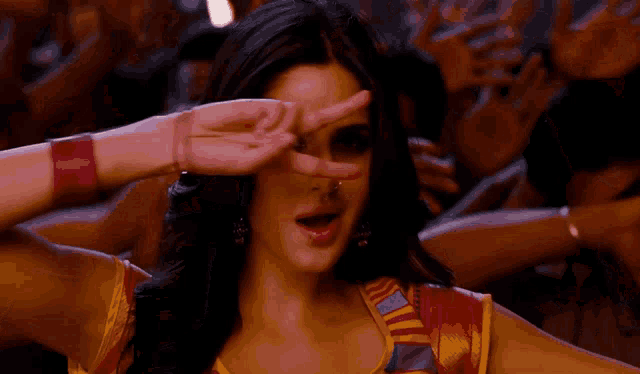 a woman with a nose ring is making a peace sign