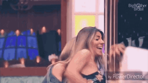 a woman laughs in front of a big brother brasil logo