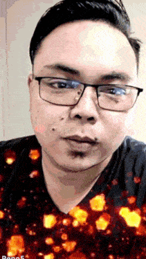 a man wearing glasses and a black shirt has a red background