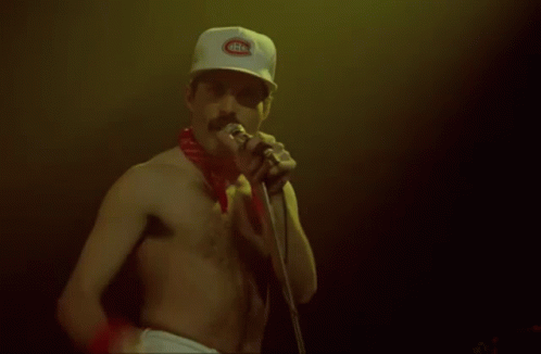 a man without a shirt is singing into a microphone wearing a hat that says montreal canadiens