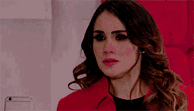a woman with red lipstick on her face looks at the camera