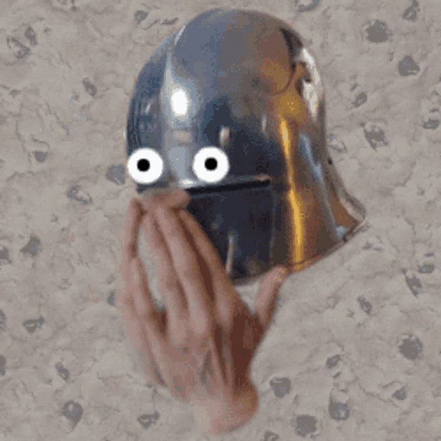 a person is holding a helmet with a cartoon face on it