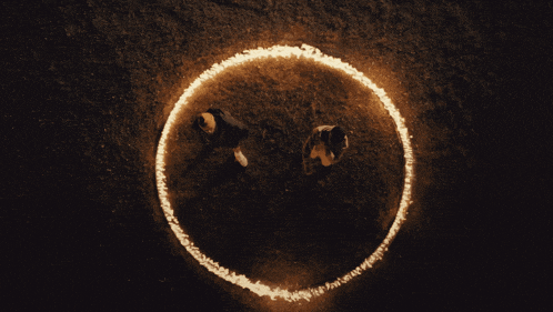 two people stand in a circle of fire
