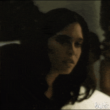 a woman is laying on a bed in a dark room .