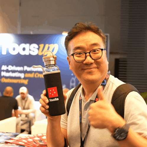 a man holds up a water bottle that says xsolla