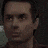 a close up of a man 's face in a dark room with a blurred background .