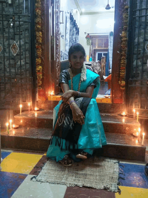 a woman in a blue dress sits in front of a door