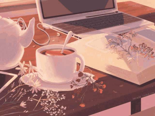a cup of tea sits on a table next to an open book