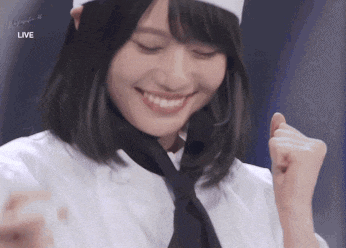 a woman wearing a chef 's hat and tie is smiling in front of a live screen