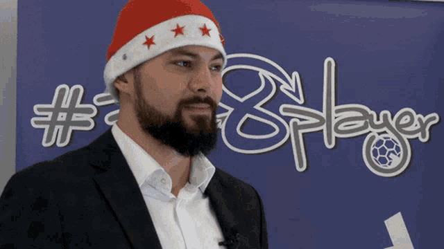 a man wearing a santa hat stands in front of a sign that says # 8 player