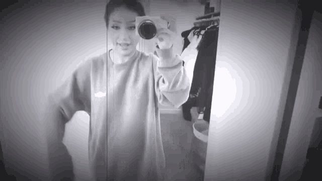 a black and white photo of a woman taking a selfie